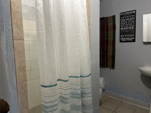 a bathroom with a toilet and a shower curtain