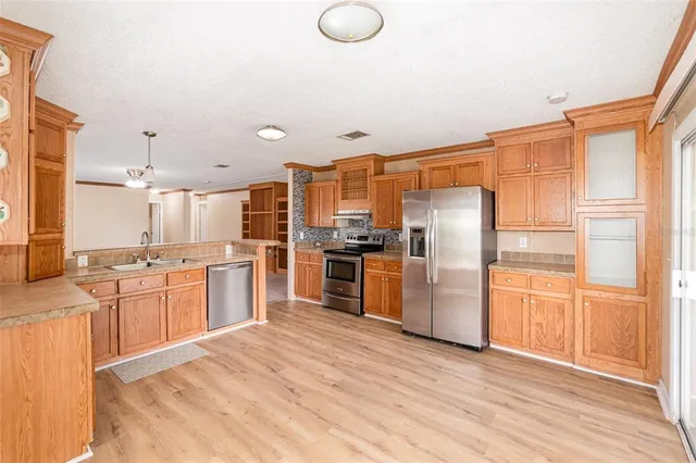 a kitchen with granite countertop stainless steel appliances refrigerator sink and cabinets