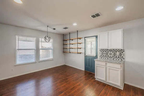 a kitchen with granite countertop wooden floors and white cabinets