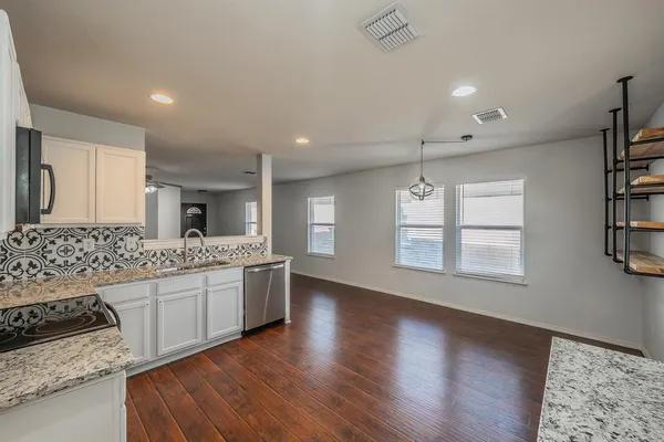 a kitchen with stainless steel appliances granite countertop a sink stove and cabinets