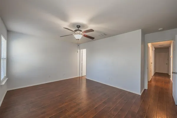 a view of an empty room with wooden floor