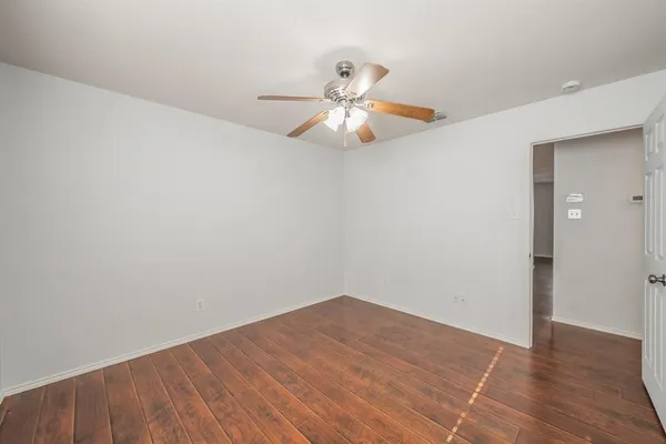 a view of an empty room with chandelier fan