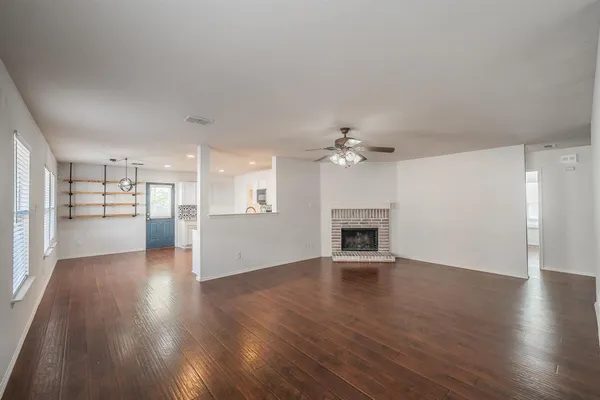 a view of empty room with wooden floor and fireplace