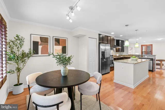 a kitchen with stainless steel appliances kitchen island granite countertop a dining table and chairs
