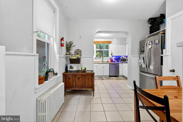a dining room filled with furniture and a refrigerator