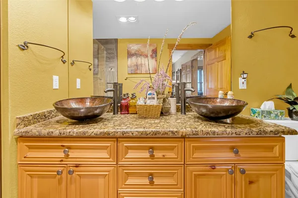 a bathroom with a granite countertop sink and a mirror
