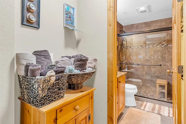 a bathroom with a granite countertop sink a toilet and shower