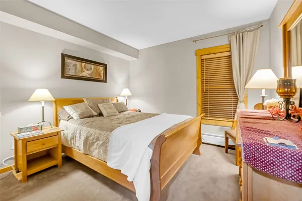 a bedroom with a bed and a lamp on table