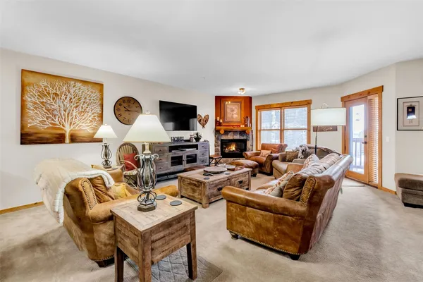 a living room with fireplace furniture and a large window