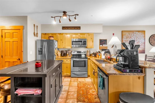 a kitchen with stainless steel appliances granite countertop a stove a sink and a refrigerator