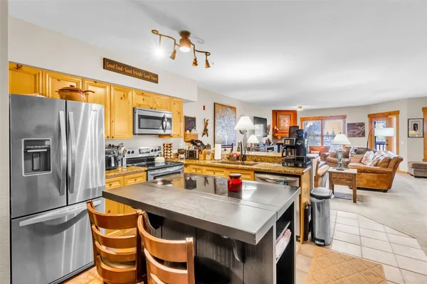 a kitchen with a table chairs and refrigerator