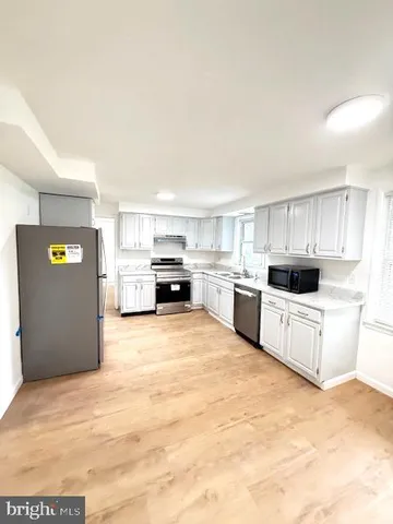 a large white kitchen with stainless steel appliances
