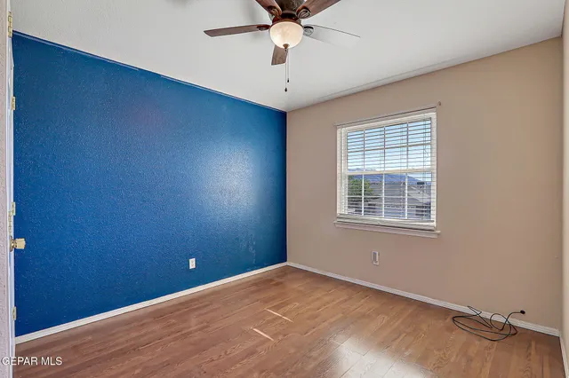 an empty room with windows and fan