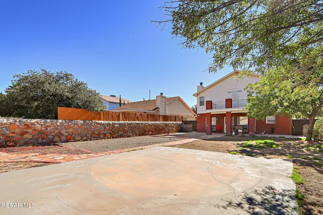 a view of a white house with a big yard and large trees