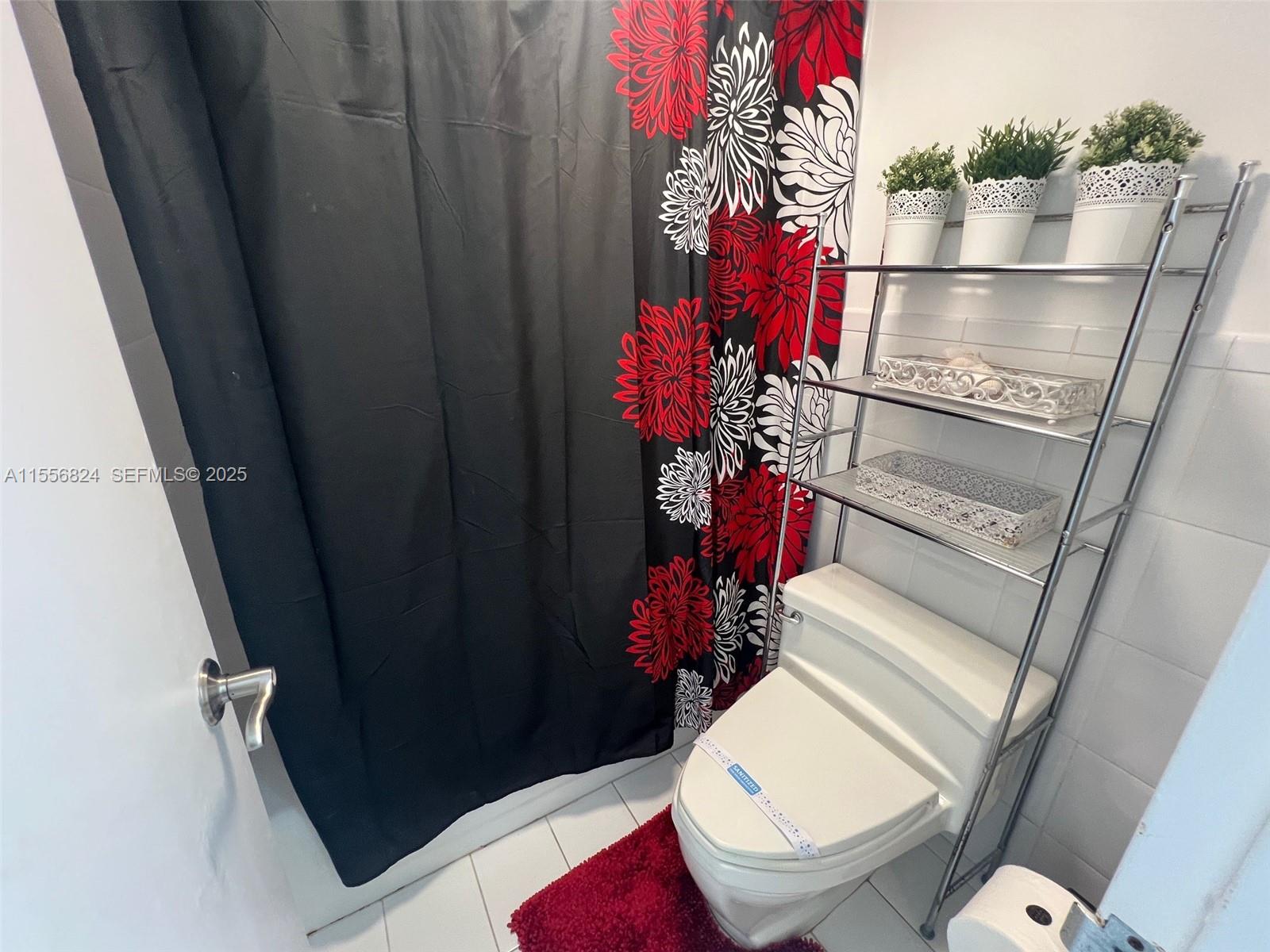 100 Lincoln Road, Unit 1126 Miami Beach, FL 33139 - Photo 12 of 52 a bathroom with a toilet and a shower curtain