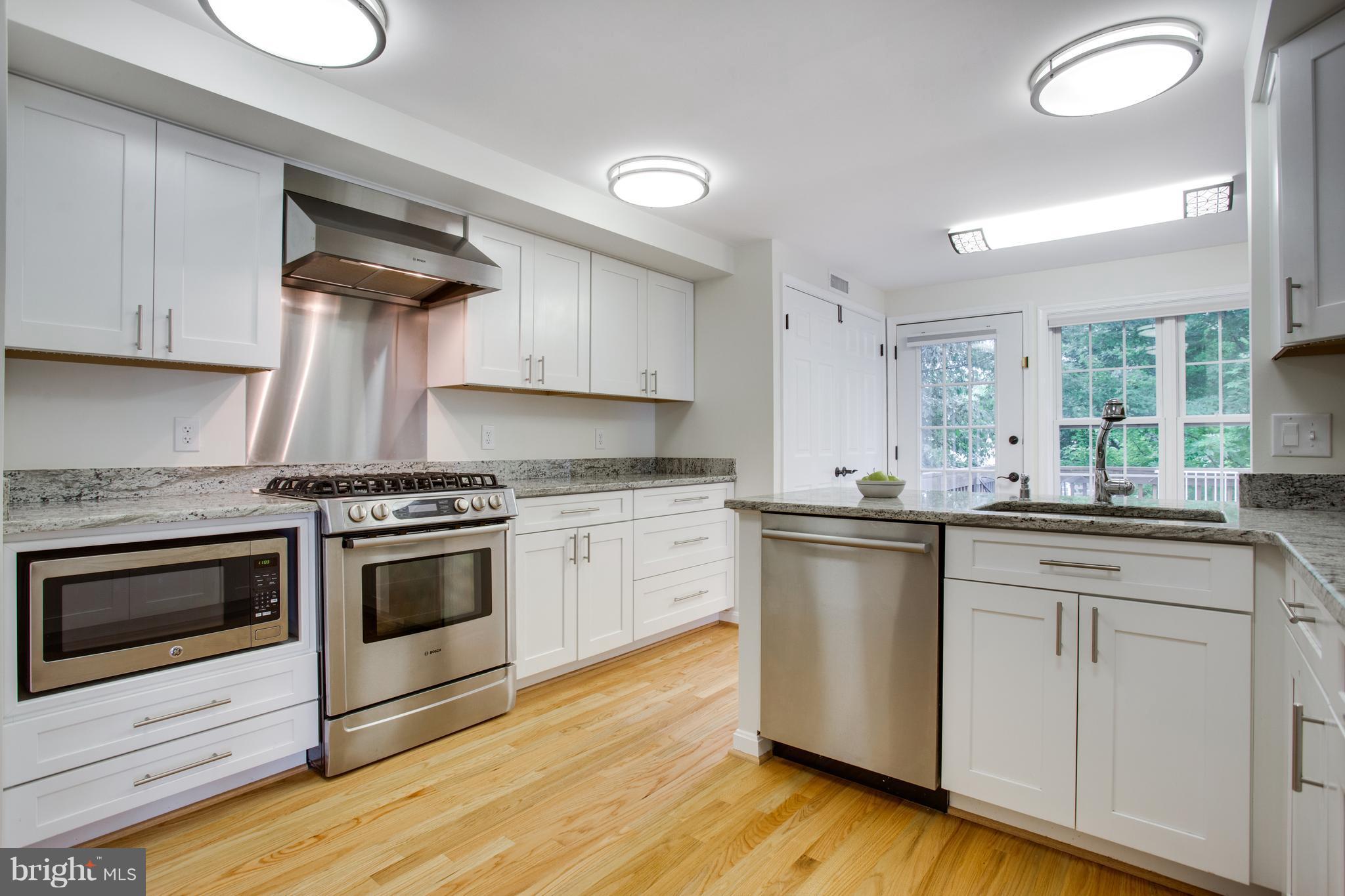 1511 Deer Point Way Reston, VA 20194 - Photo 2 of 30 a kitchen with granite countertop white cabinets and white appliances