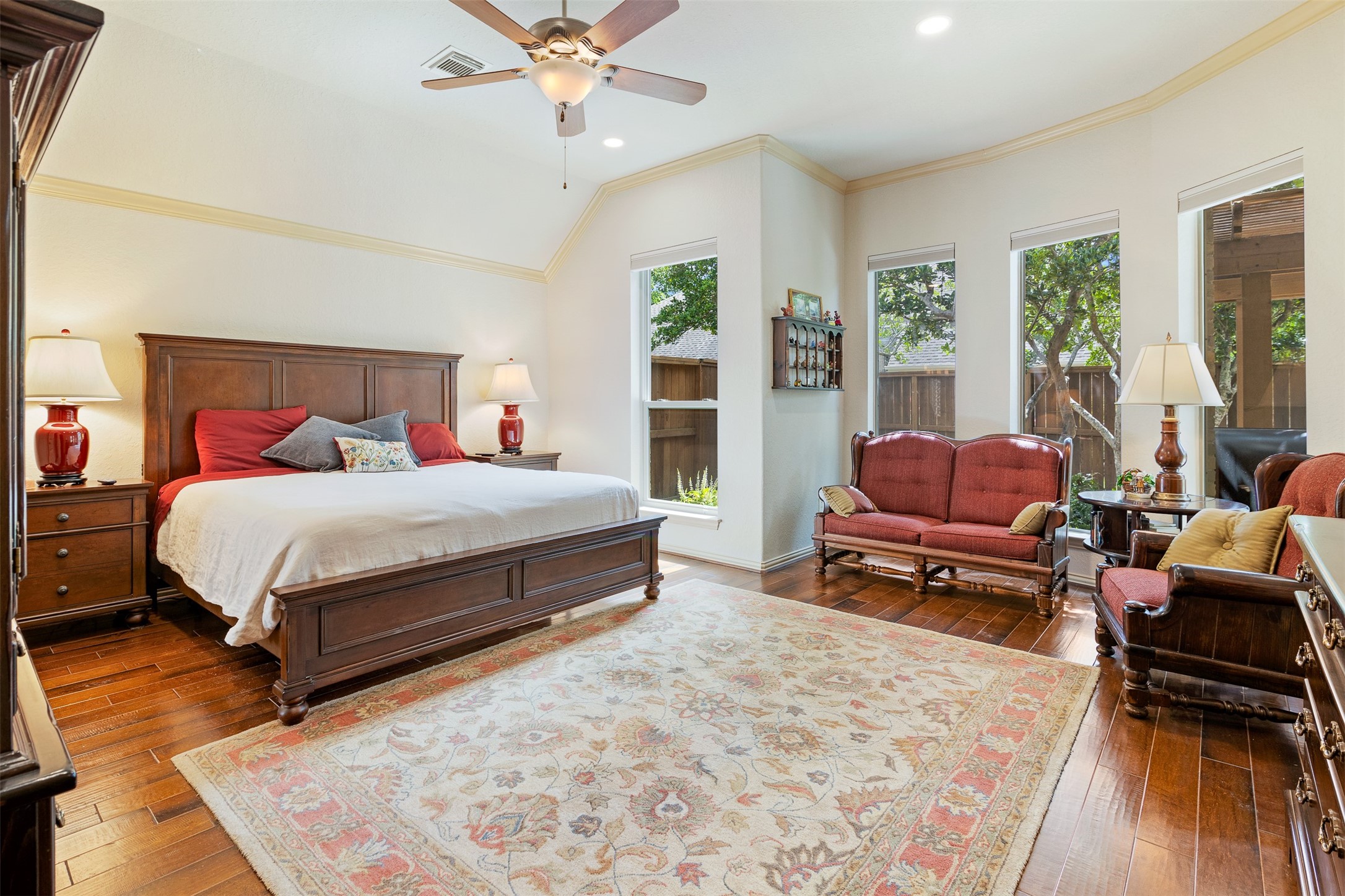 19507 Remington Manor Street Spring, TX 77379 - Photo 14 of 33 The primary bedroom is your own private retreat with wood floors, elevated ceiling with fan and wall of windows looking out into the backyard.