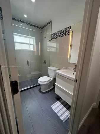 a bathroom with a toilet a sink a mirror and a bathtub