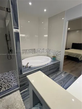 a bathroom with a bathtub a sink and a shower