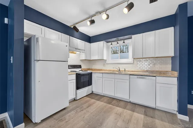 a view of a kitchen with wooden floor and a ceiling fan