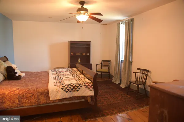 a bedroom with a bed chandelier and a window