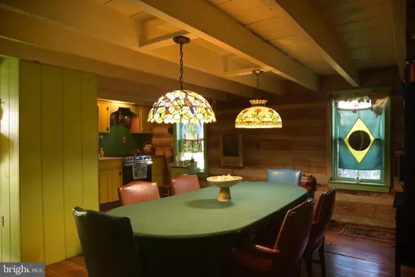 a dining room with furniture a chandelier and wooden floor