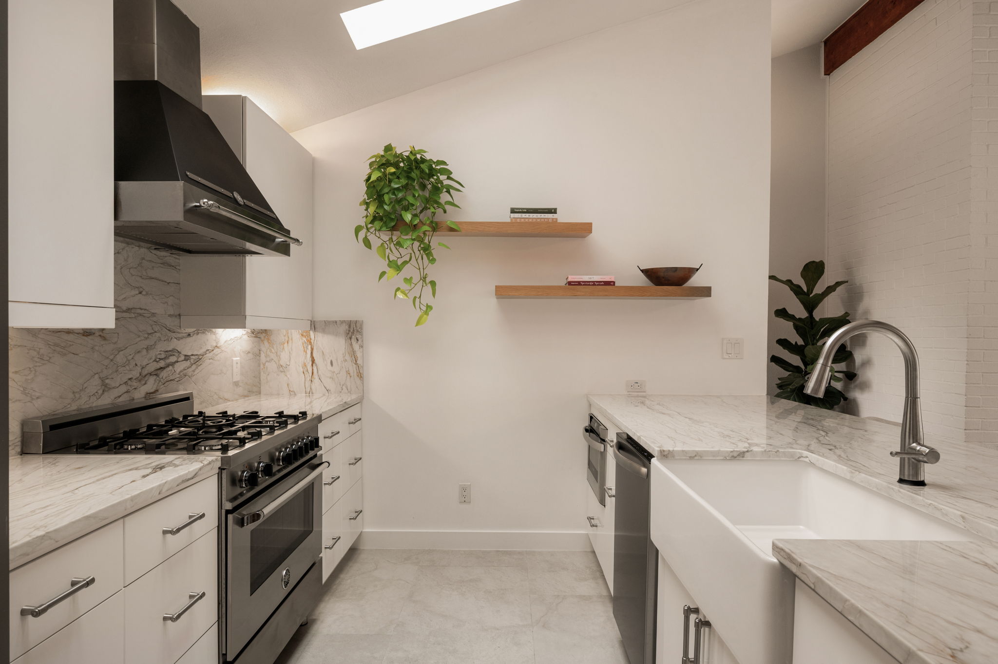6501 Sumac Drive Austin, TX 78731 - Photo 5 of 40 Kitchen with stainless steel appliances, light stone countertops, a skylight, open shelves, and lofted ceiling