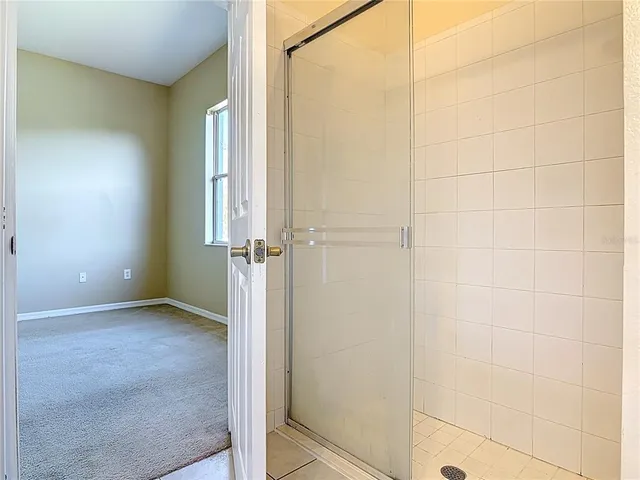 an empty room with a window and ceiling fan