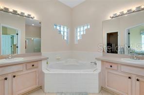 4325 Wordsworth Way Venice, FL 34293 - Photo 17 of 24 a bathroom with a bathtub a double vanity sink and a mirror