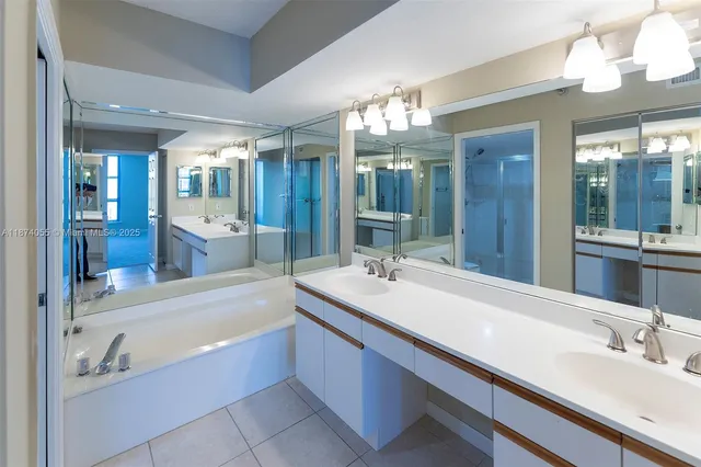 a bathroom with a bathtub double sink and a mirror