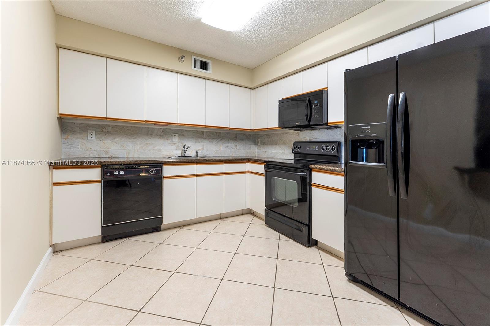 3530 Mystic Pointe Drive, Unit 2207 Aventura, FL 33180 - Photo 6 of 26 a kitchen with stainless steel appliances granite countertop a refrigerator sink and cabinets