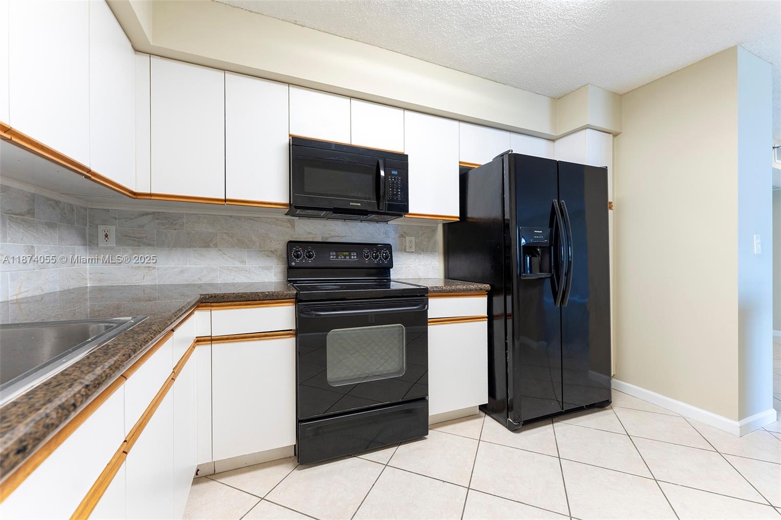 3530 Mystic Pointe Drive, Unit 2207 Aventura, FL 33180 - Photo 7 of 26 a kitchen with stainless steel appliances granite countertop a refrigerator and a stove top oven