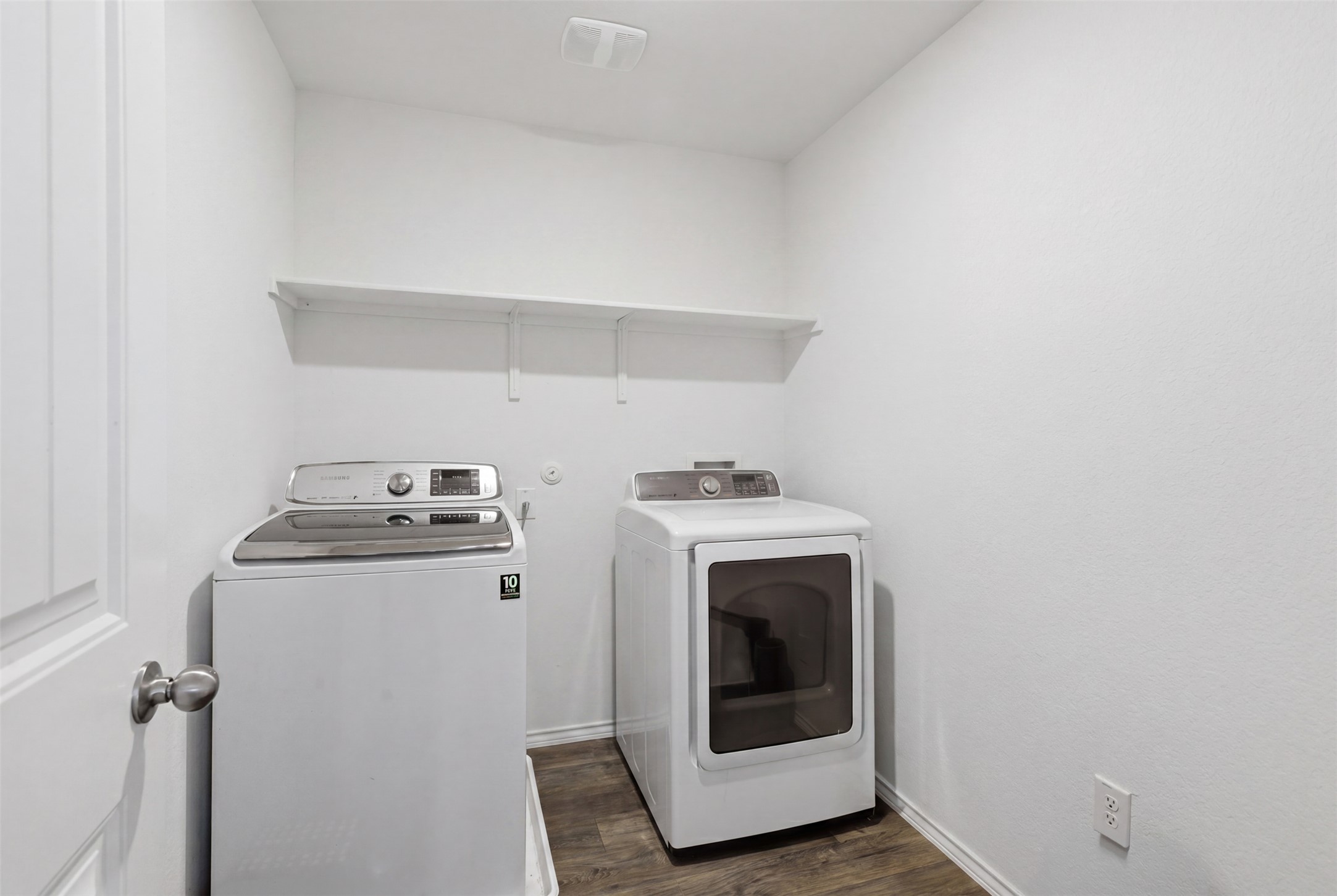 19017 Romano Drive Elgin, TX 78621 - Photo 7 of 33 Dedicated laundry area featuring wood-finish flooring, crisp white walls, and a convenient wall-mounted shelf