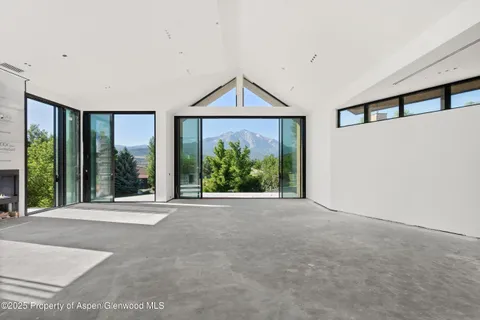 a view of a room with large windows and a rug