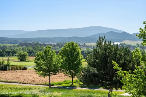 a view of a lush green hillside and a building