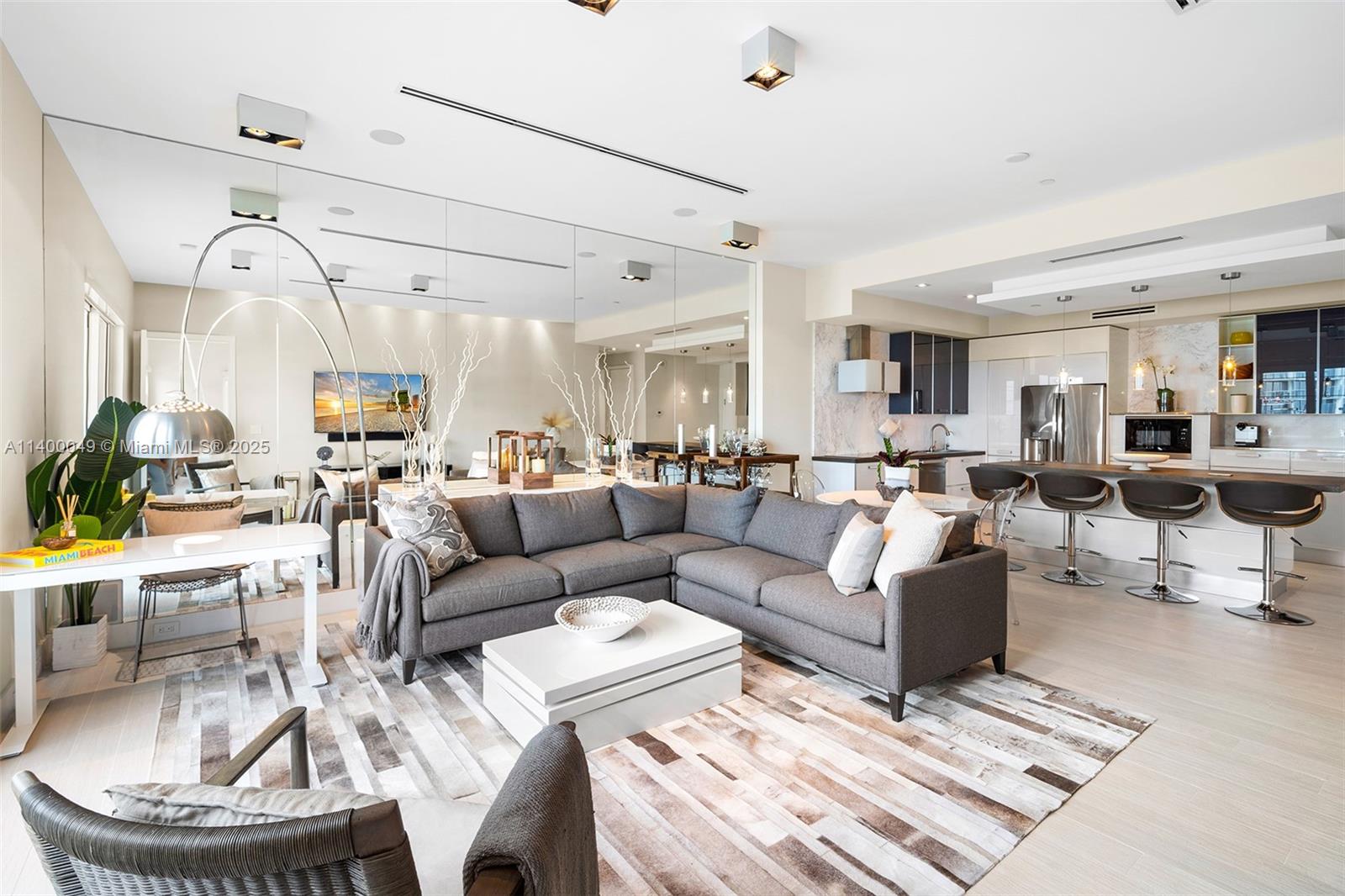a living room with couches a coffee table and kitchen view