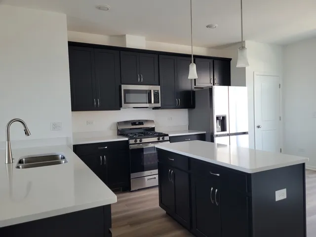 a kitchen with a sink a stove a refrigerator and cabinets