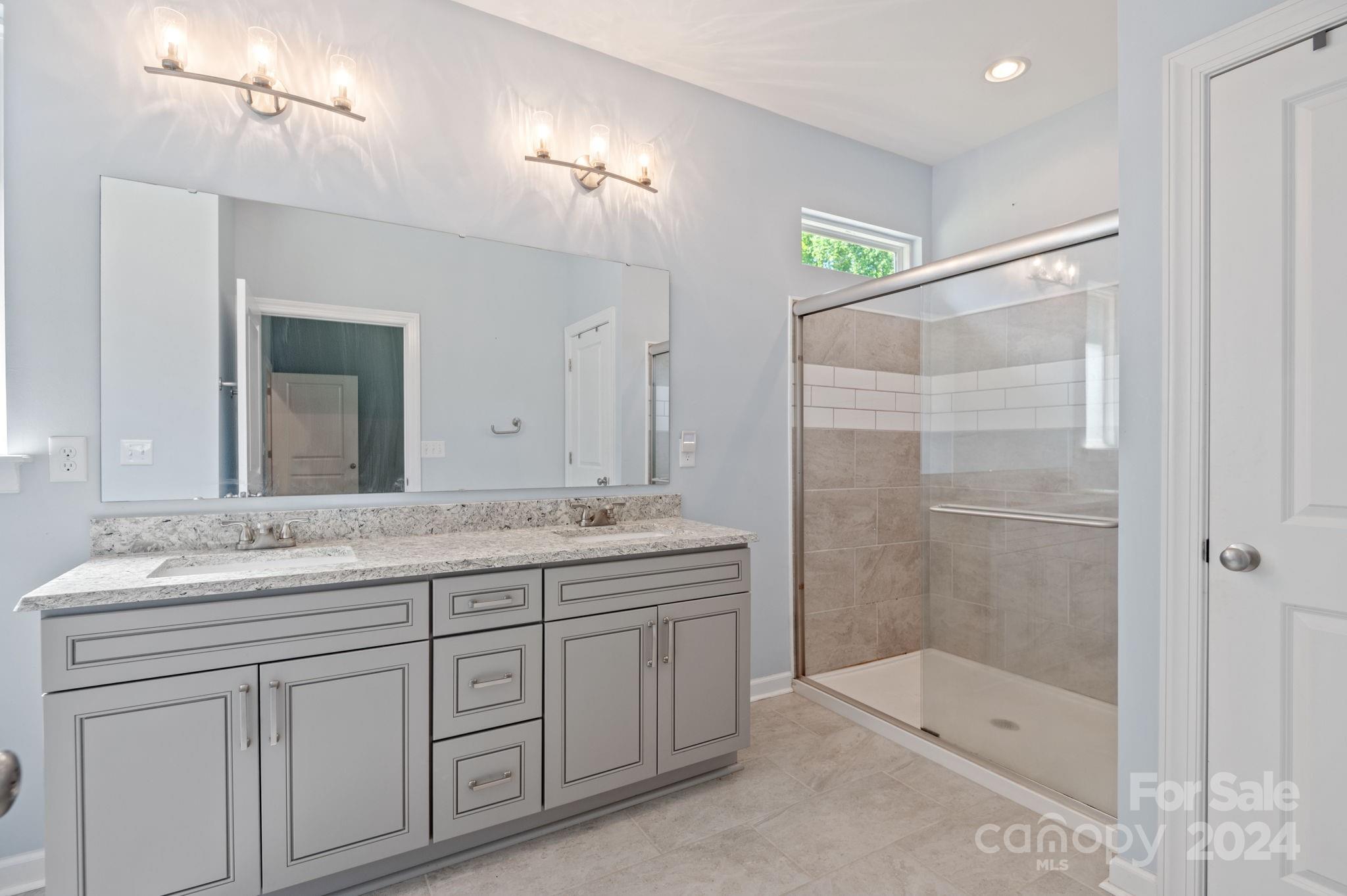 4655 Old Hickory Road Lancaster, SC 29720 - Photo 21 of 35 a bathroom with a granite countertop sink a mirror and a shower