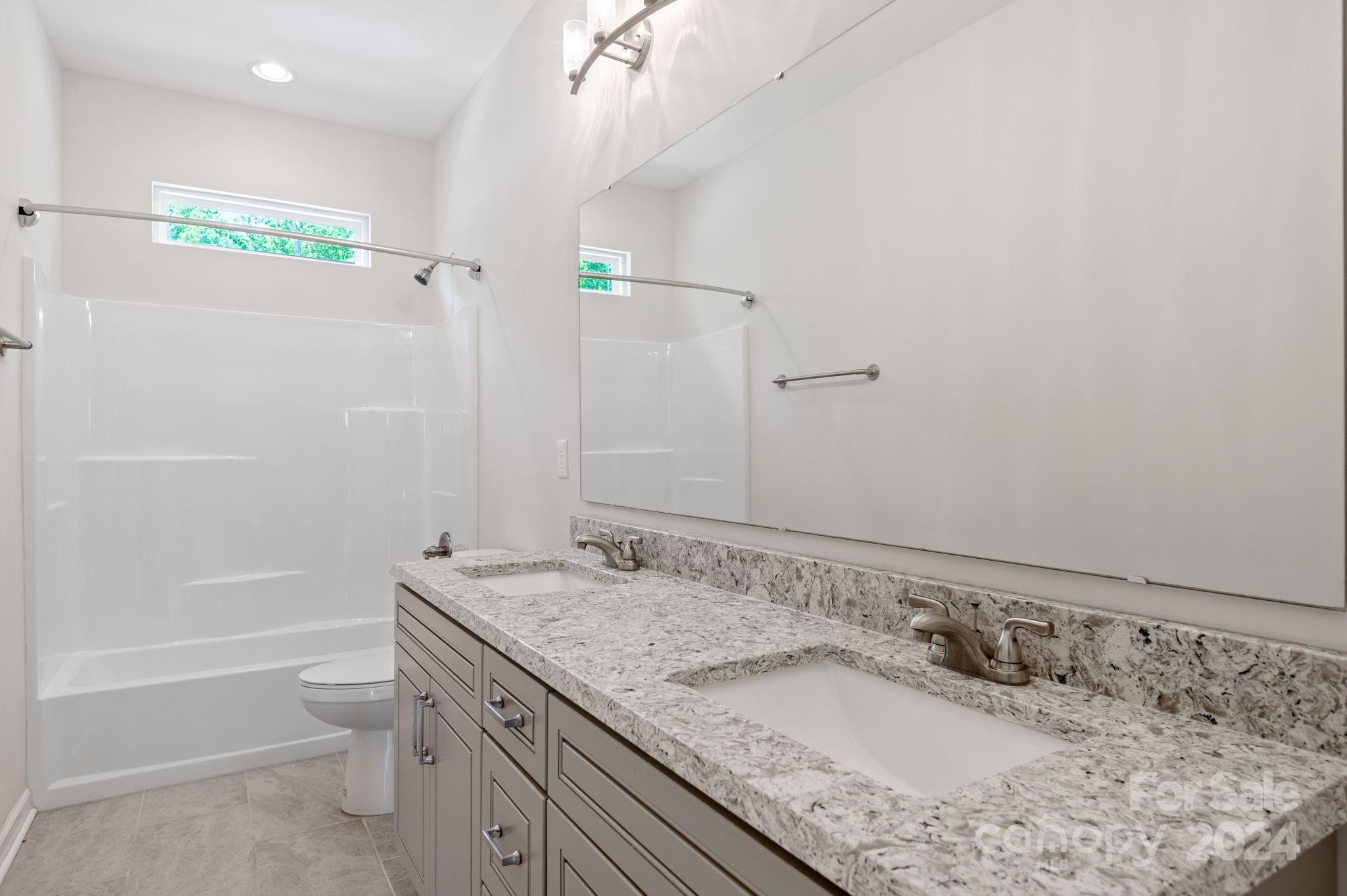 4655 Old Hickory Road Lancaster, SC 29720 - Photo 27 of 35 a bathroom with a granite countertop sink a toilet and shower