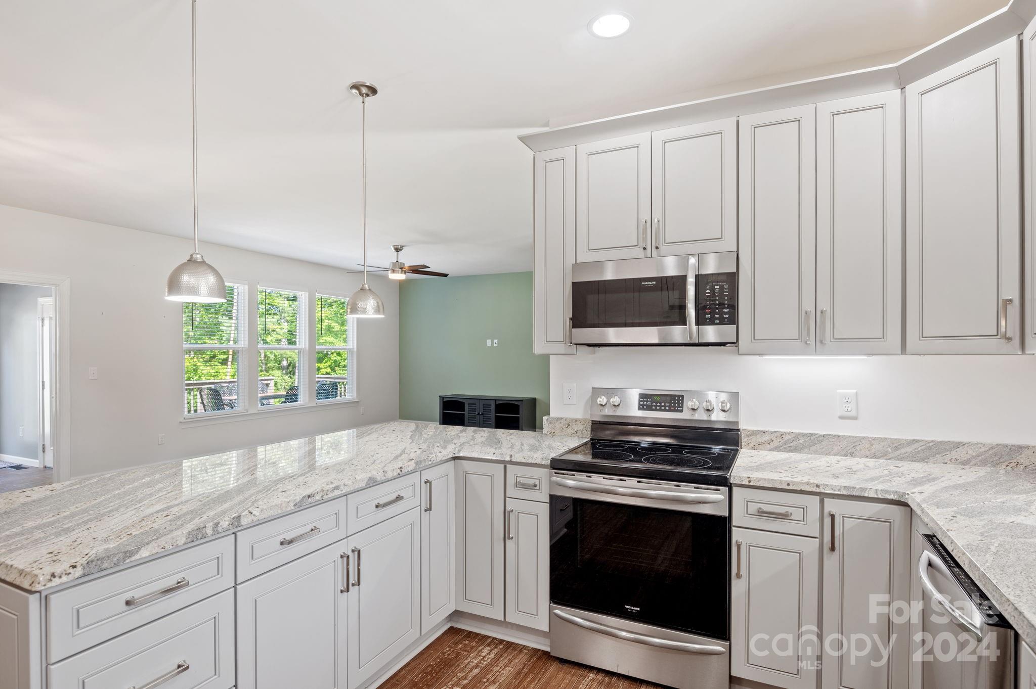 4655 Old Hickory Road Lancaster, SC 29720 - Photo 8 of 35 a kitchen with granite countertop a stove a sink and a microwave