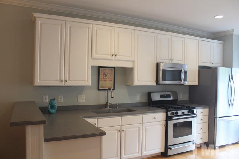 1322 Cameron View Court Raleigh, NC 27607 - Photo 2 of 22 a kitchen with stainless steel appliances granite countertop a refrigerator a stove a sink and white cabinets