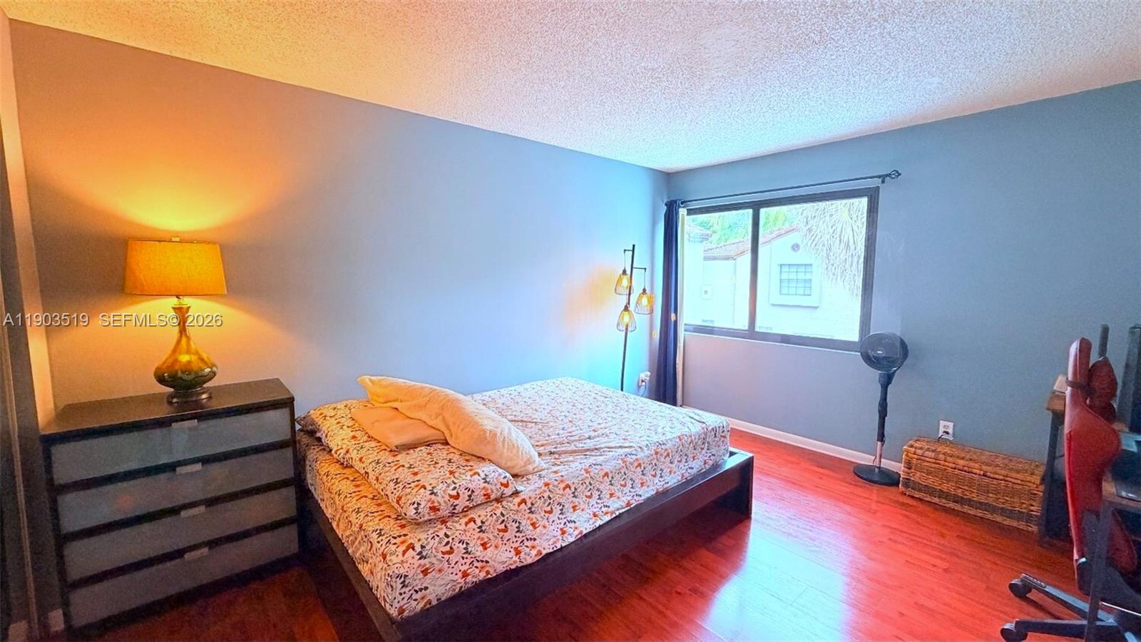 10515 Southwest 153rd Court, Unit 3 Miami, FL 33196 - Photo 15 of 32 a bedroom with a bed and a lamp on dresser