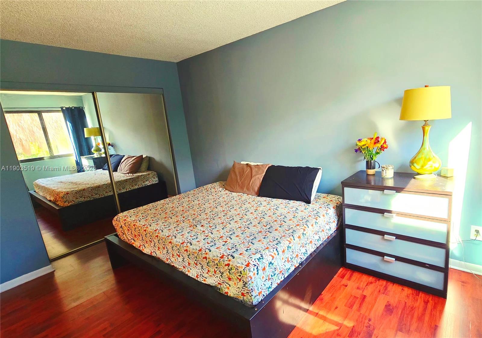 10515 Southwest 153rd Court, Unit 3 Miami, FL 33196 - Photo 16 of 26 a bedroom with a bed and dresser with wooden floor