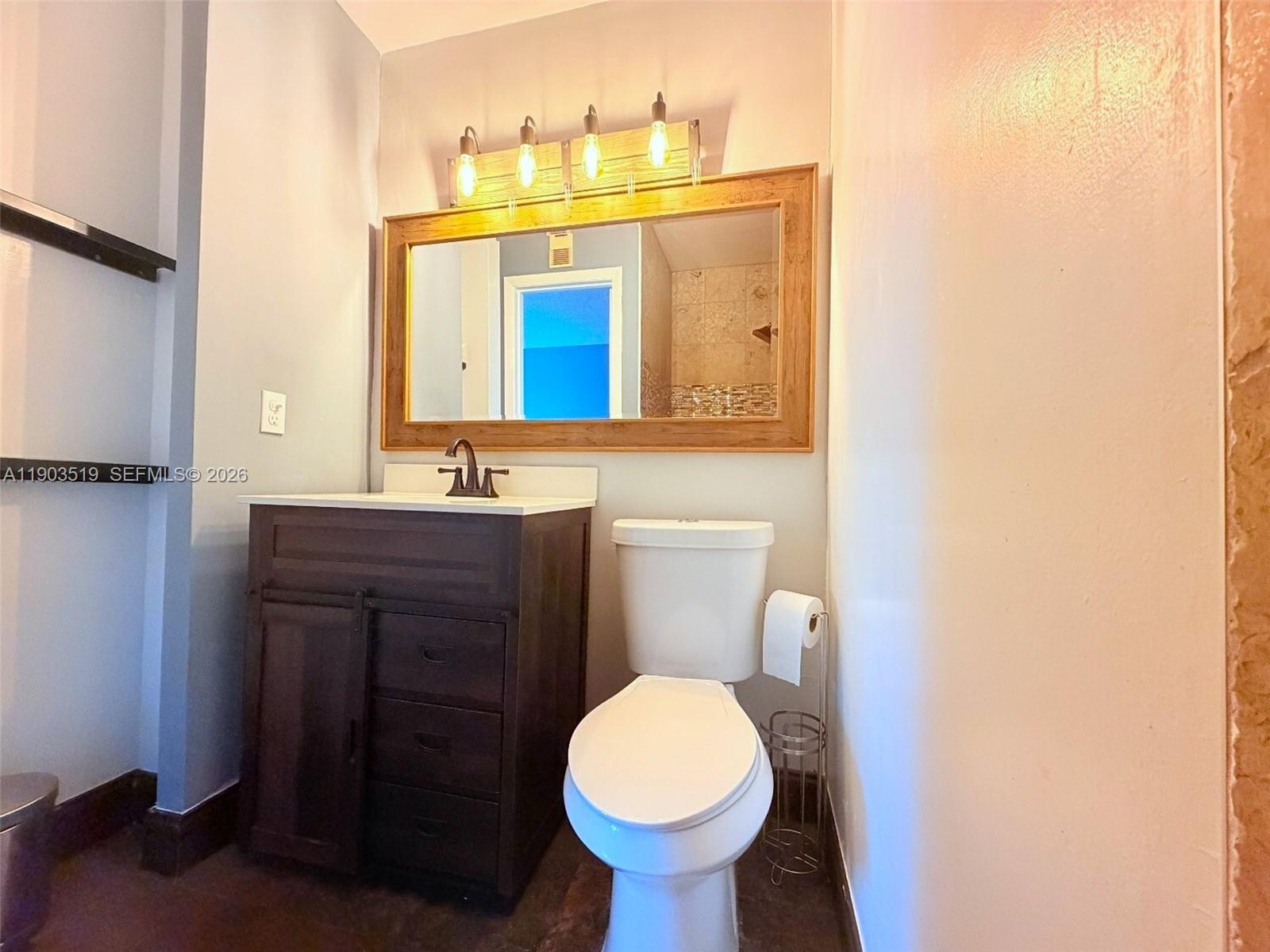 10515 Southwest 153rd Court, Unit 3 Miami, FL 33196 - Photo 19 of 32 a bathroom with a toilet sink and mirror