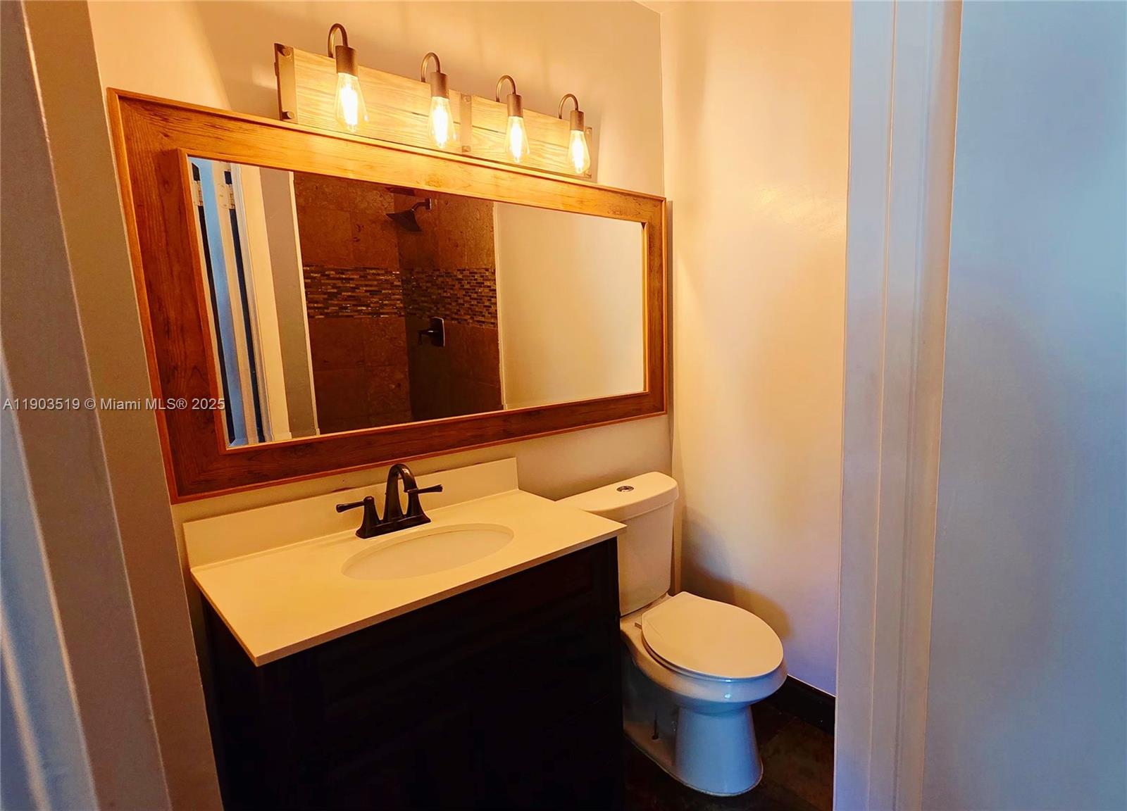 10515 Southwest 153rd Court, Unit 3 Miami, FL 33196 - Photo 22 of 26 a bathroom with a sink and a mirror