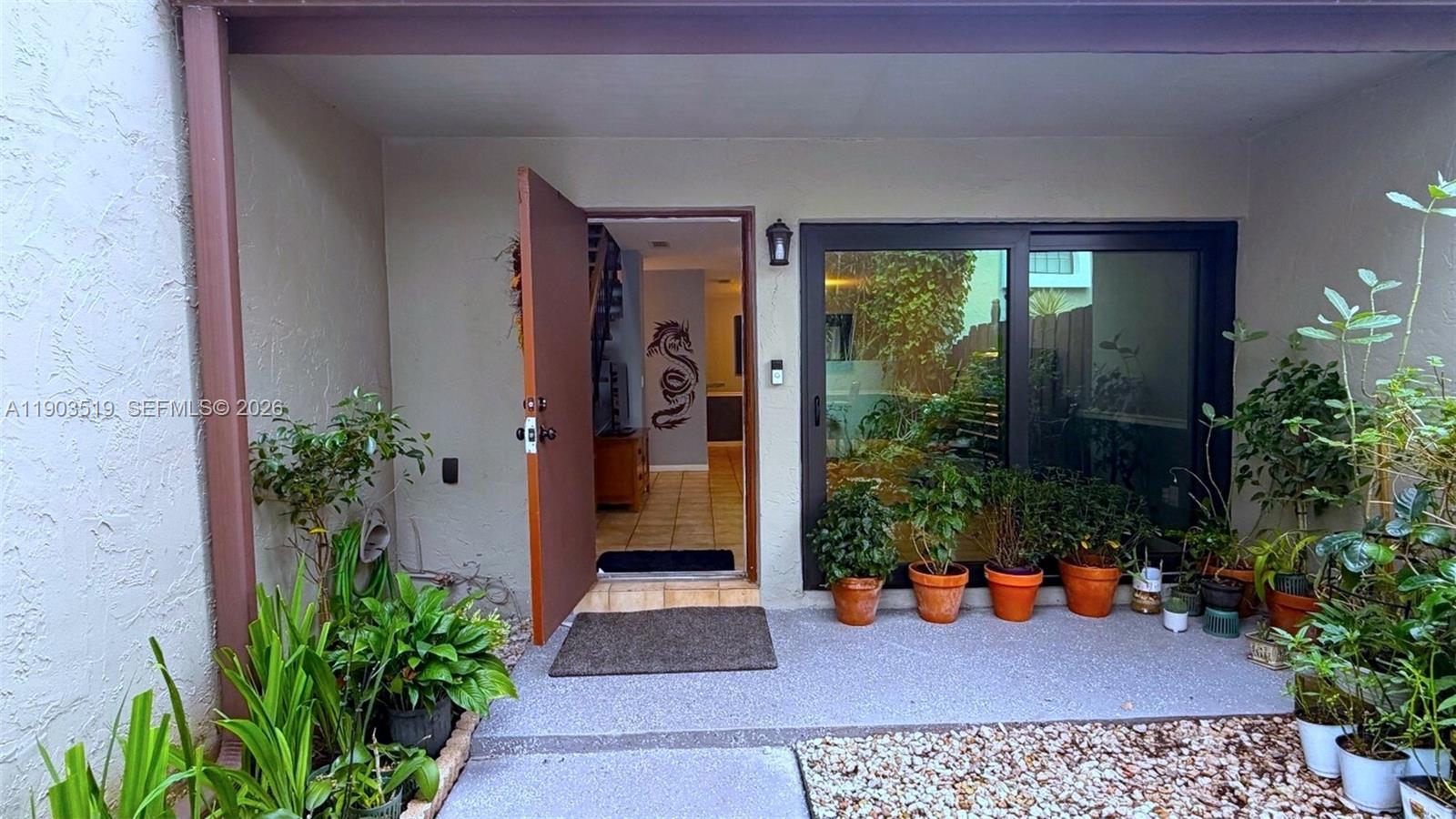 10515 Southwest 153rd Court, Unit 3 Miami, FL 33196 - Photo 5 of 32 a potted plant sitting in front of a house