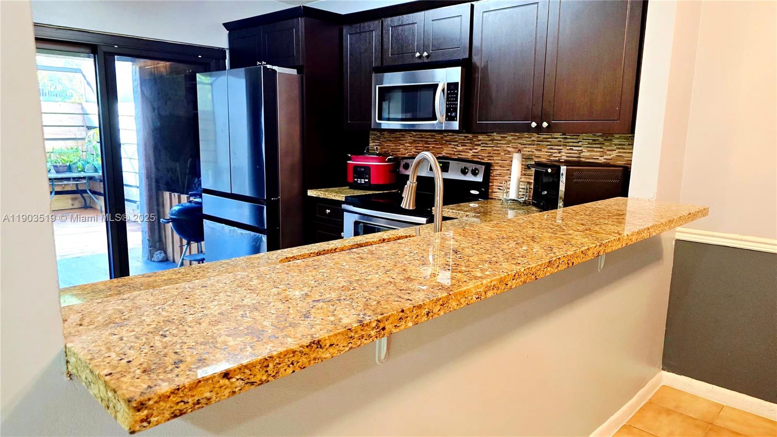 10515 Southwest 153rd Court, Unit 3 Miami, FL 33196 - Photo 7 of 26 a kitchen with stainless steel appliances granite countertop a refrigerator stove and microwave