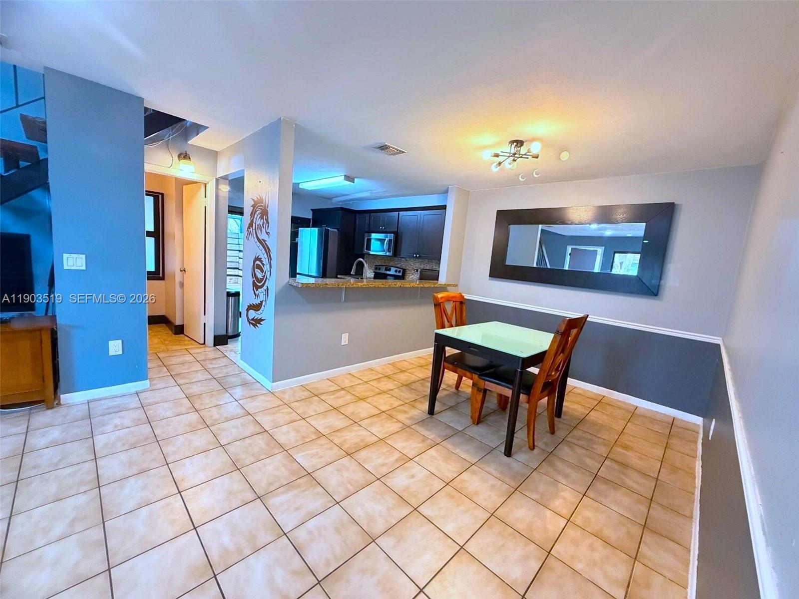 10515 Southwest 153rd Court, Unit 3 Miami, FL 33196 - Photo 9 of 32 a living room with furniture and a dining table with rug