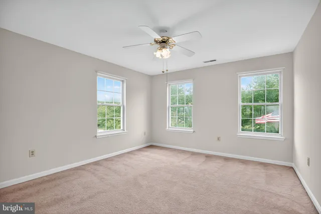 a view of a livingroom with a ceiling fan and window