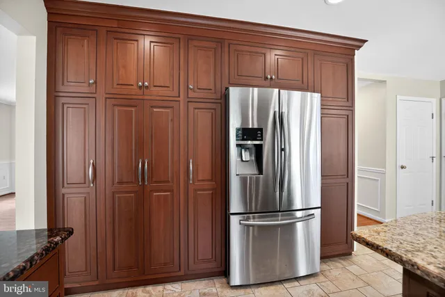 a kitchen with refrigerator and wooden cabinets